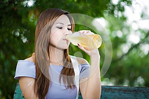 Beautiful young woman drinks water from bottle