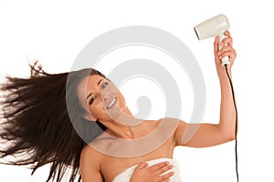 Beautiful young woman drying hair with hair dryer isolated over