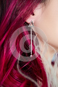 Beautiful young woman with dyed hair purple red color, bright beauty makeup close-up. Strong colored hair