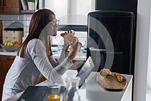 Beautiful young woman early in the morning having breakfast at home