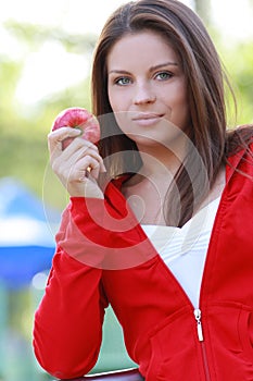 Beautiful young woman eating apple.