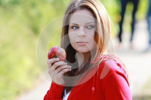 Beautiful young woman eating apple.