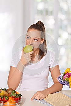 Beautiful young woman eating an apple
