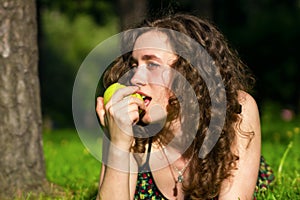 Beautiful young woman eating apple