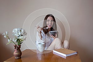 Beautiful young woman eating cereals