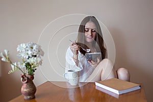 Beautiful young woman eating cereals