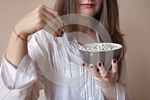 Beautiful young woman eating cereals