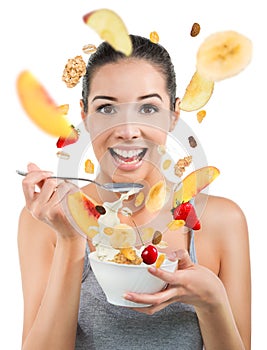 Beautiful young woman eating cereals and fruit