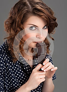 Beautiful young woman eating chocolate