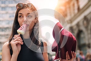 Beautiful young woman eating ice cream in the summer