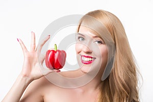 Beautiful young woman eating paprika