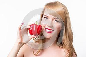 Beautiful young woman eating paprika