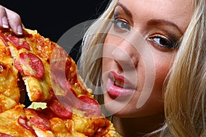 Beautiful young woman eating pizza photo