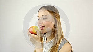 Beautiful young woman eating a red apple