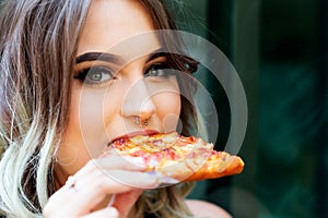 Beautiful Young Woman eating Slice of hot Pizza. Popular Fast Food concept.