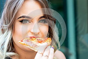 Beautiful Young Woman eating Slice of hot  Pizza. Popular Fast Food concept.