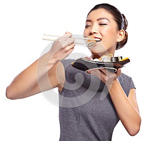 Beautiful young woman eating sushi.