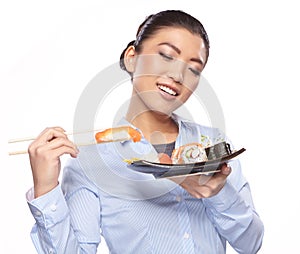 Beautiful young woman eating sushi.