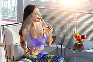 Beautiful Young Woman Eating Vegetable Salad . Healthy Diet. Beautiful Smiling Woman Eating Fresh Organic Vegetarian Salad.