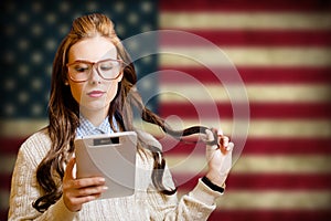 Beautiful young woman with ebook on USA flag