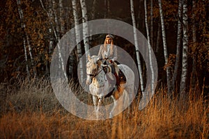 Beautiful young woman in English hunter wear style with Knabstrupper horse