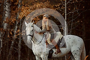 Beautiful young woman in English hunter wear style with Knabstrupper horse