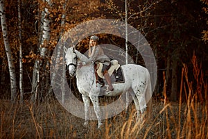 Beautiful young woman in English hunter wear style with Knabstrupper horse