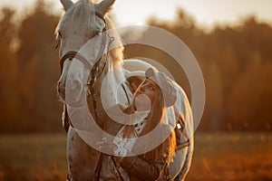 Beautiful young woman in English hunter wear style with Knabstrupper horse