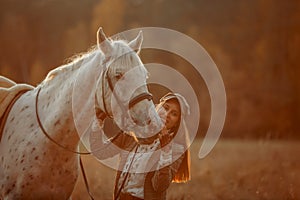 Beautiful young woman in English hunter wear style with Knabstrupper horse