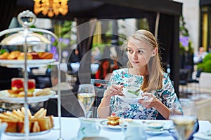 Beautiful young woman enjoying afternoon tea