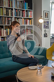 Beautiful young woman enjoying a coffee at a library cafe