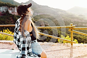 Beautiful young woman enjoying nature at mountain peak.