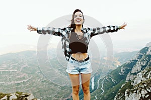 Beautiful young woman enjoying nature at mountain peak.