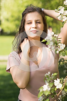 Beautiful young woman enjoying nature in the spring apple orchard, happy Beautiful girl in the garden with flowering