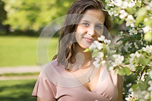 Beautiful young woman enjoying nature in the spring apple orchard, happy Beautiful girl in the garden with flowering