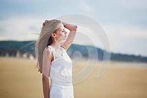 Beautiful young woman enjoying sun on a sand beach