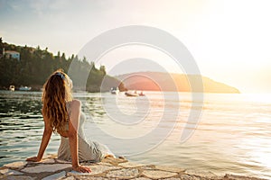 Beautiful young woman enjoying the sunset at the sea