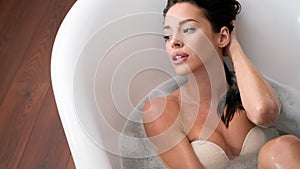 Beautiful young woman enjoying time in bathtub