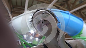 Beautiful young woman enjoys spending time in the water park smiling looking at the camera. slow motion