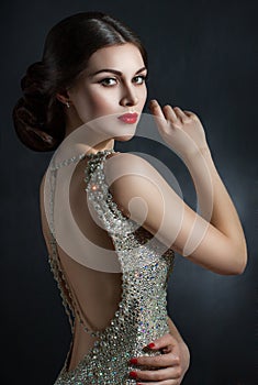 Beautiful young woman in an evening dress crystal. Perfect beauty, red lips, bright makeup. Twinkling sparkling stones on dress