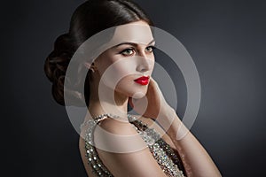 Beautiful young woman in an evening dress crystal. Perfect beauty, red lips, bright makeup. Twinkling sparkling stones on dress