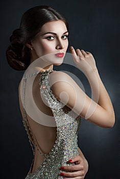 Beautiful young woman in an evening dress crystal. Perfect beauty, red lips, bright makeup. Twinkling sparkling stones on dress photo