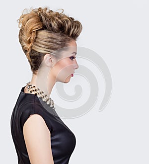 Beautiful young woman with evening make-up and salon hairdo . Smoky eyes. Complicated hairstyle for party