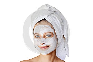 Beautiful young woman with facial mask on her face. Skin care and treatment, spa, natural beauty and cosmetology concept, isolated