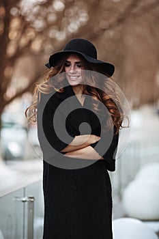 Beautiful young woman in fashion black coat, hat, lace dress an