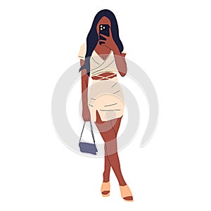 Beautiful young woman in a fashionable dress takes off herself on a smartphone.