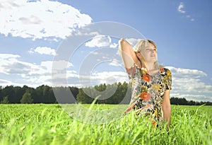 Beautiful young woman on field in summer time