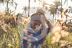 Beautiful young woman on a field at sunset