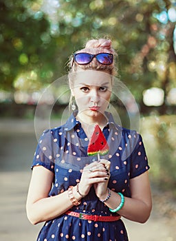 Beautiful young woman in fifties style with candy