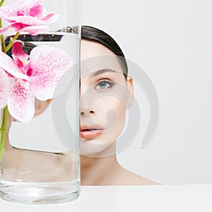 Beautiful young Woman and Flowers in the Bottle